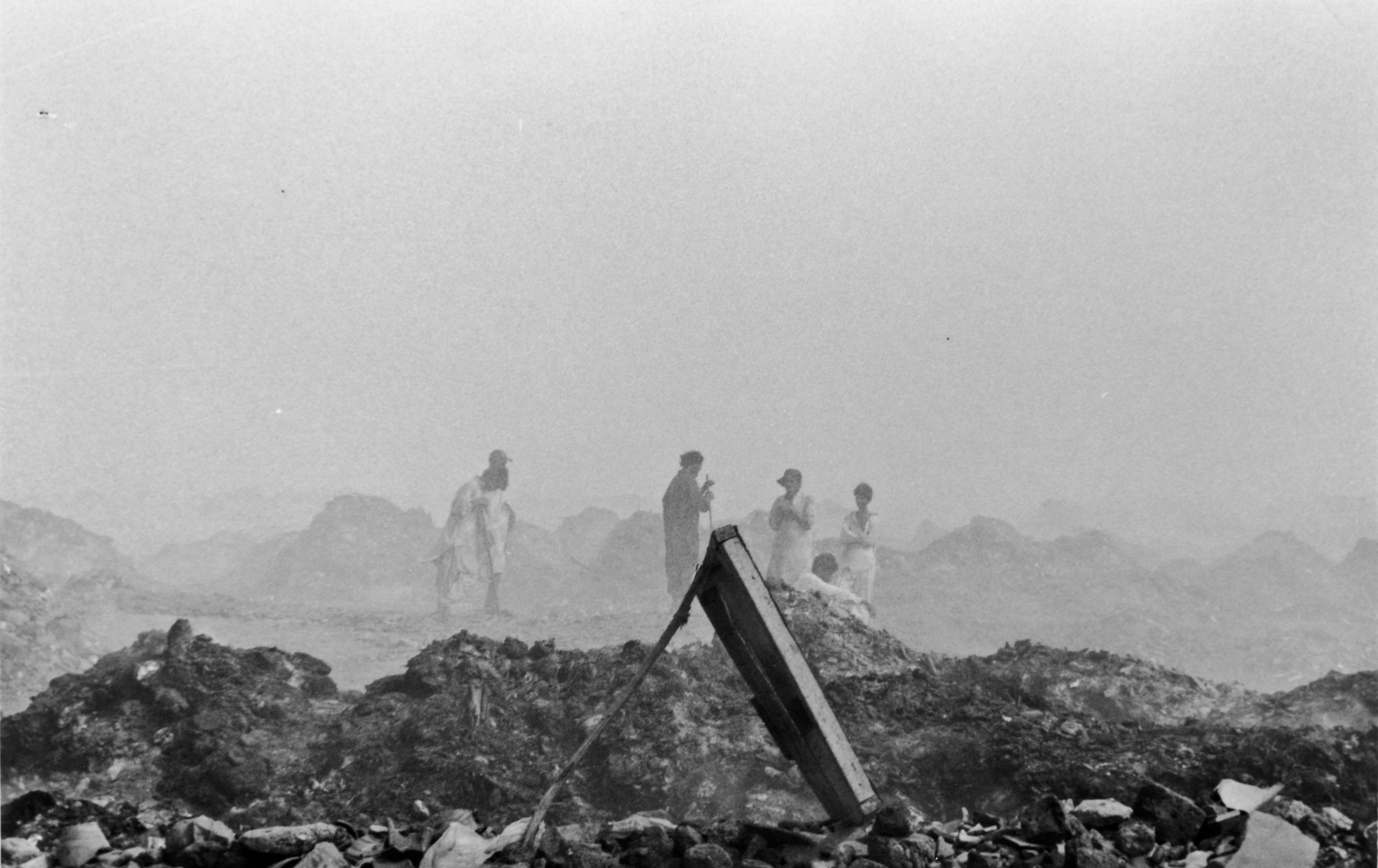 workers take a break from sifting through landfill